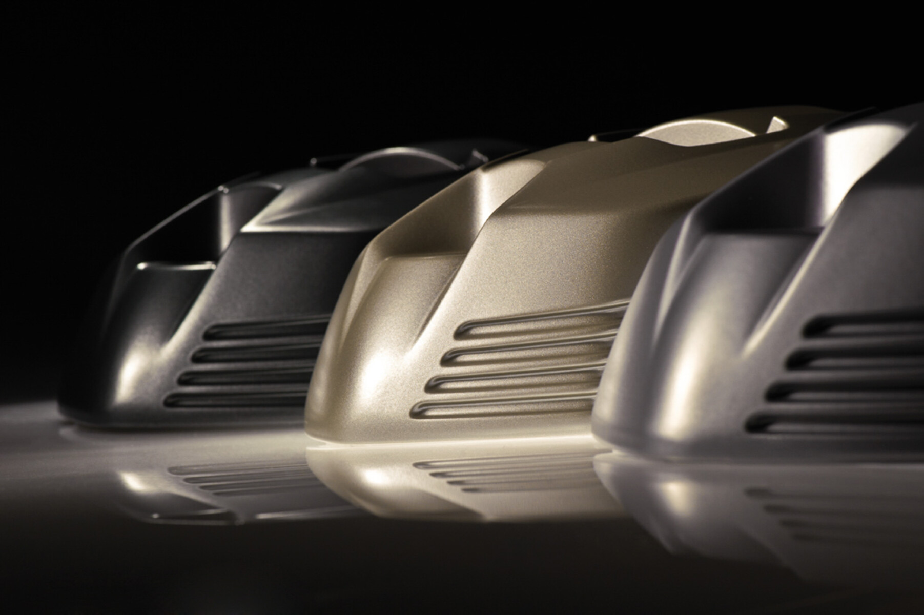 Drei Metallteile mit reflektierenden Oberflächen